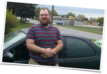 Photo of Patrick McQuay standing next to his car